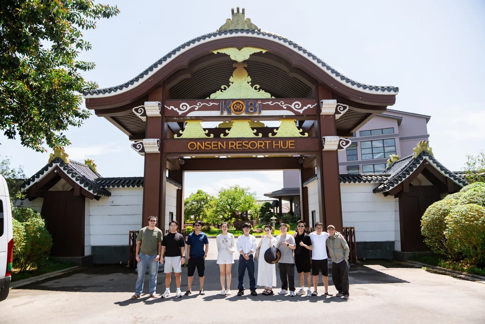Kobi Onsen Resortの看板がある門の前で撮影した集合写真